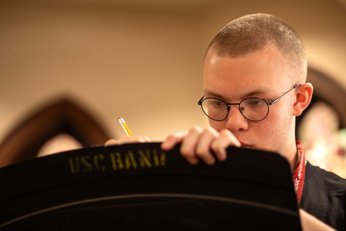 Trombone player Jacob Corley writes down new notes after on his line paper after a post-preformance debrief. As a result of their shared interest, trombone specialist Nathan Duvall has been able to work more closely with Corley "I take... the
horns, so we have two trombones, a flute, and a saxophone, and so the four... of us stay together," Duvall said.