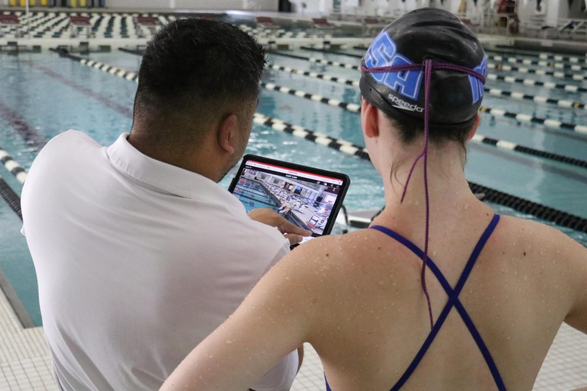 Camp Director Jason Calanog reviews above water footage with a swimmer. Calanog, who also serves as Carolina Swim’s Associate Head Coach, aims to create a fun, organized environment for swimmers while helping them improve their technique. “The biggest key with this generation is keeping it simple and giving them direct feedback,” Calanog stated. 