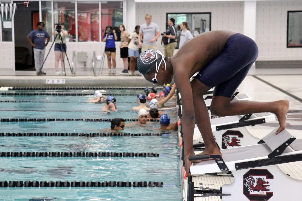 A swimmer prepares to dive for his one-on-one analysis session with the coaches. The cameras will capture above and below water footage, side view recording, and shots of his starts and turns. 